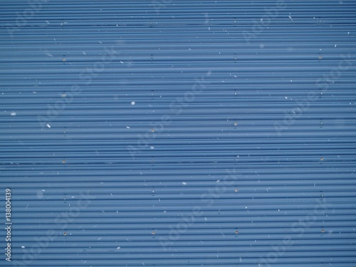 青いシャッターに降り続く雪