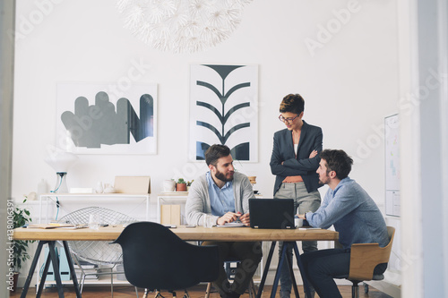 Coworkers discussing in office photo
