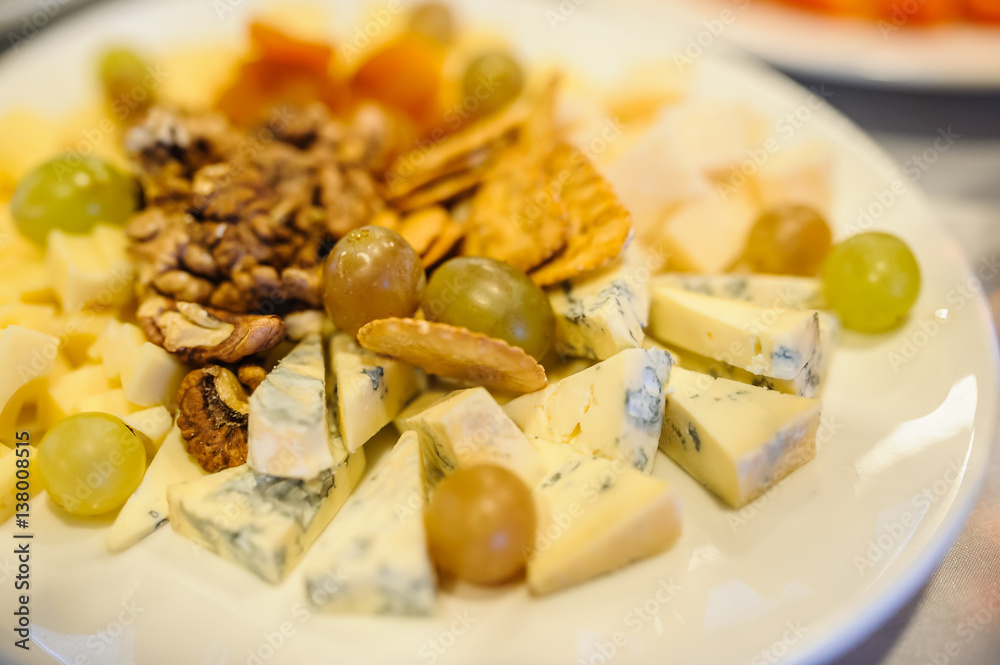 Cheese plate composition with nuts and grapes Cheese plate composition with nuts and grapes
