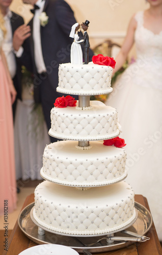gorgeous white wedding cake on the background of the newlyweds