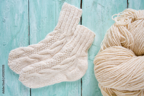 knitted socks and yarn on wooden surface photo