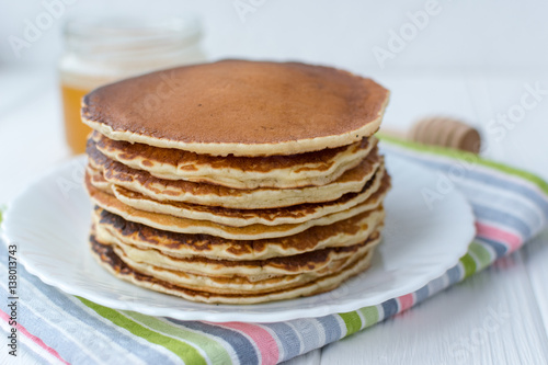 Healthy breakfast. Stack of delicious, homemade pancakes with honey, cherry and banana on white plate 