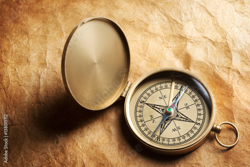 antique compass on vintage paper background