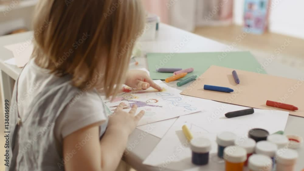 Cute Little Girl Sits at Her Table and Draws. She Paints Sun with Her Yellow Finger. Her Room Is Pink and Cosy. Shot on RED EPIC-W 8K Helium Cinema Camera. Cute Little Girl Sits at Her Table and Draws. She Paints Sun with Her Yellow Finger. Her Room Is Pink and Cosy. Shot on RED EPIC-W 8K Helium Cinema Camera.