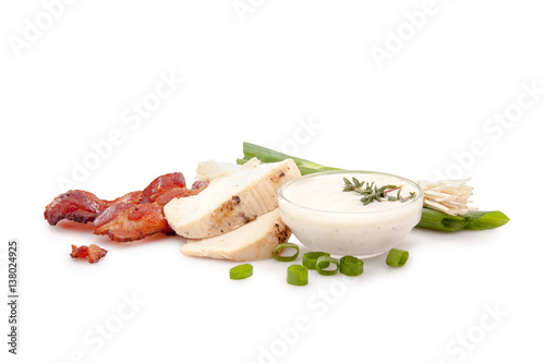 Chicken, bacon, ranch dressing and green onions on white