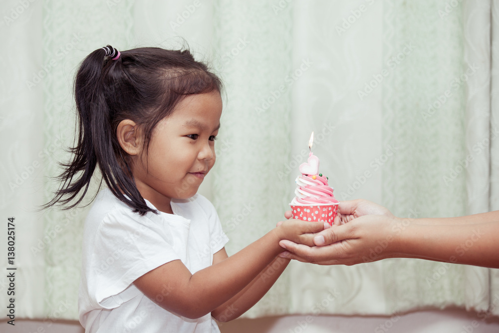asian little girl having fun to blowing birthday cupcake in vintage color tone asian little girl having fun to blowing birthday cupcake in vintage color tone