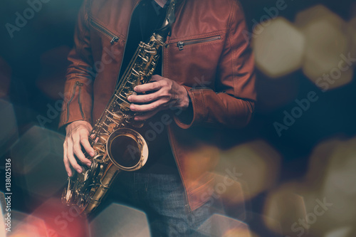 Jazz saxophone player in performance on the stage. color filter and hexagon bokeh added.