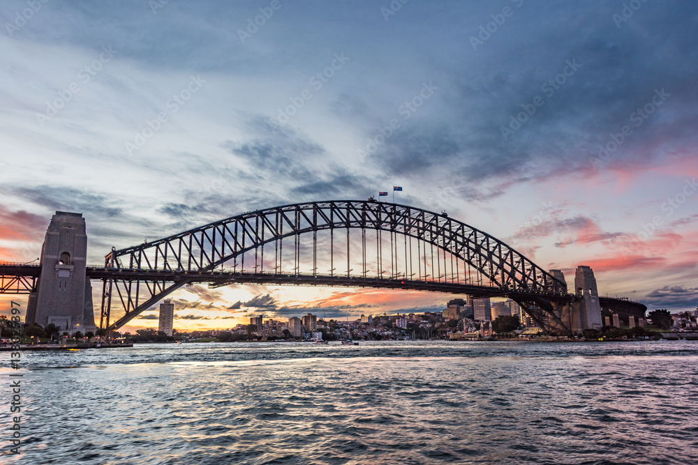 Australian iconic landmark Sydney Harbour Bridge against picturesque sunset sky