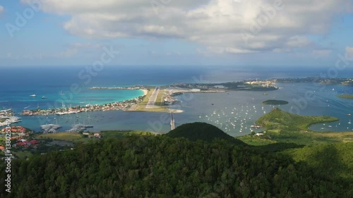 St Maartin Aerial v52 Flying low over tall hillsides sideways with views of airport and runway. photo