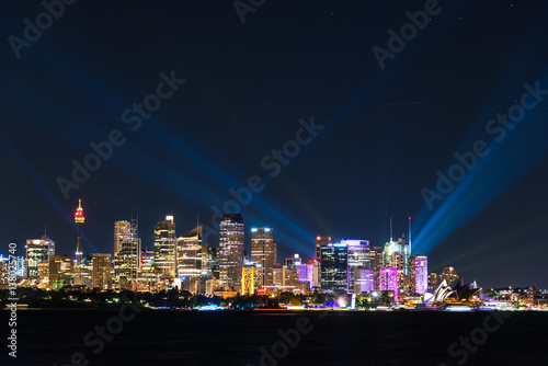 Sydney cityscape at night with colorful lights illuminating skyline