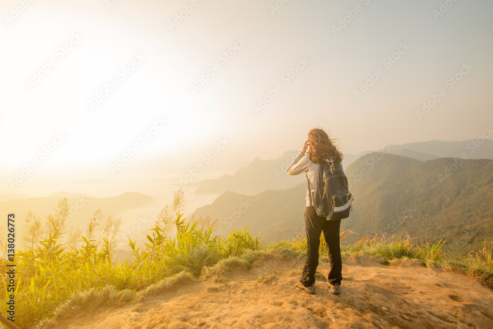 young tourist woman standing on top of mountain