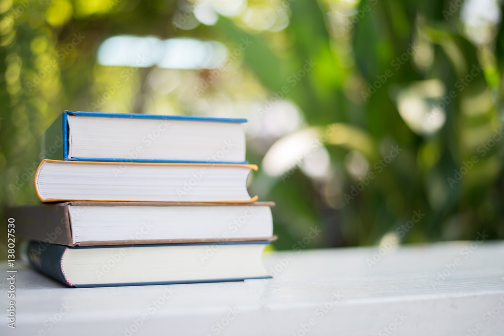 Close up pile of books, shot outdoors under clear natural bokeh background. Close up pile of books, shot outdoors under clear natural bokeh background.