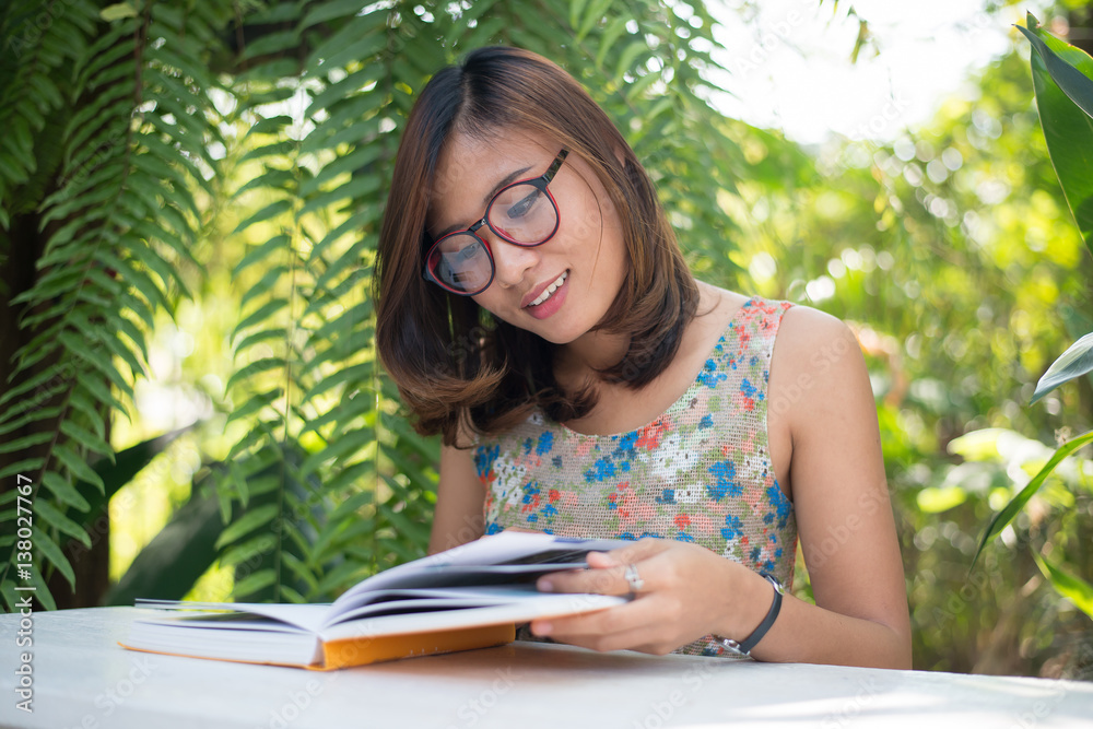 Fototapeta premium Young hipster woman reading books in home garden with nature. Education concept.