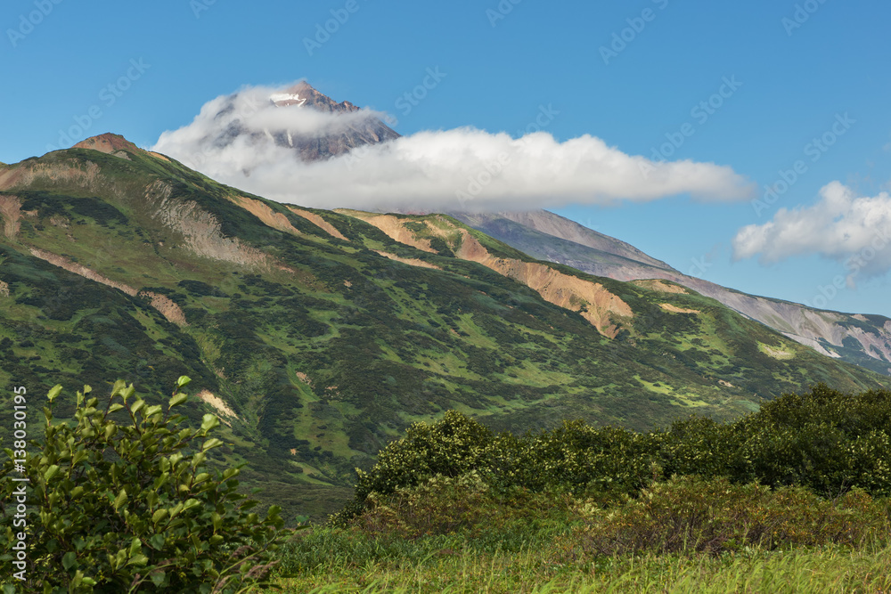 Vilyuchinsky stratovolcano in the clouds. View from brookvalley Spokoyny at the foot of outer north-eastern slope of caldera volcano Gorely.