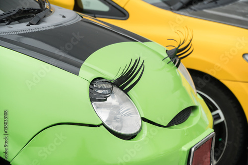 Car with eyelashes on headlightsas feminine symbol.