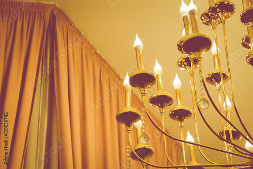 Chandelier with candles under the ceiling.