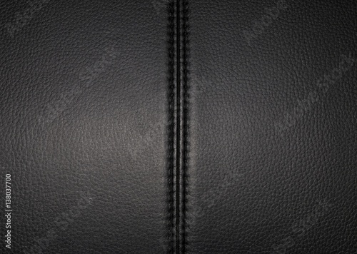 Black leather texture background surface with seam. Macro shot.