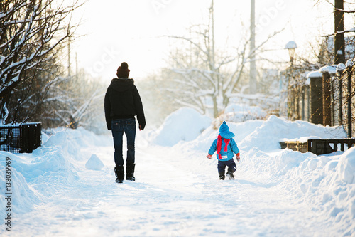 happy family with child walking in winter outdoors
