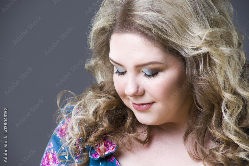 Young beautiful happy blonde plus size model in dres, xxl woman portrait on gray studio background Young beautiful happy blonde plus size model in dres, xxl woman portrait on gray studio background