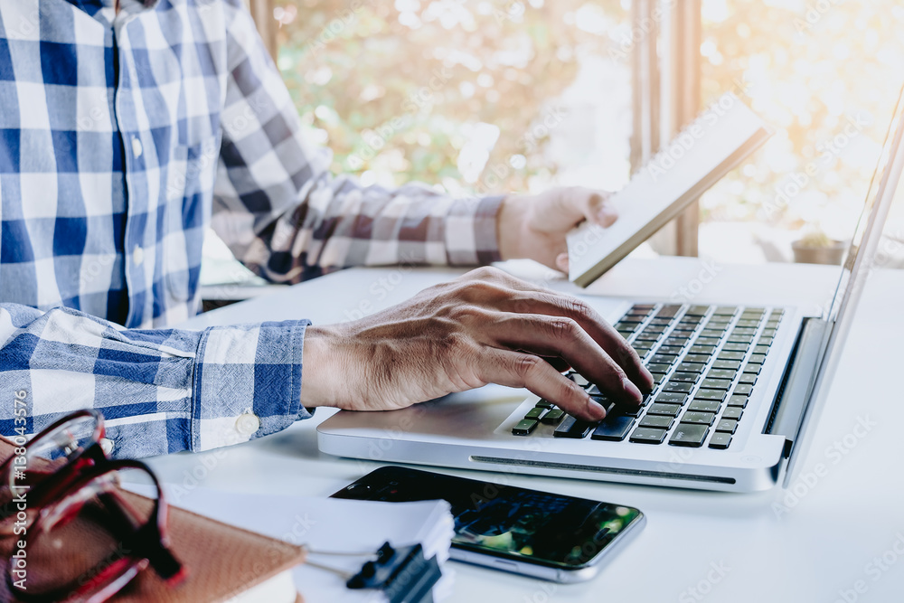 Businessman hand using and working with laptop on office desk table.Close up business team analysis and strategy concept. Businessman hand using and working with laptop on office desk table.Close up business team analysis and strategy concept.