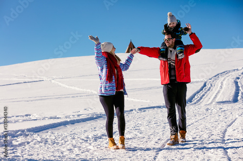 Attractive family having fun in a winter park on mountain