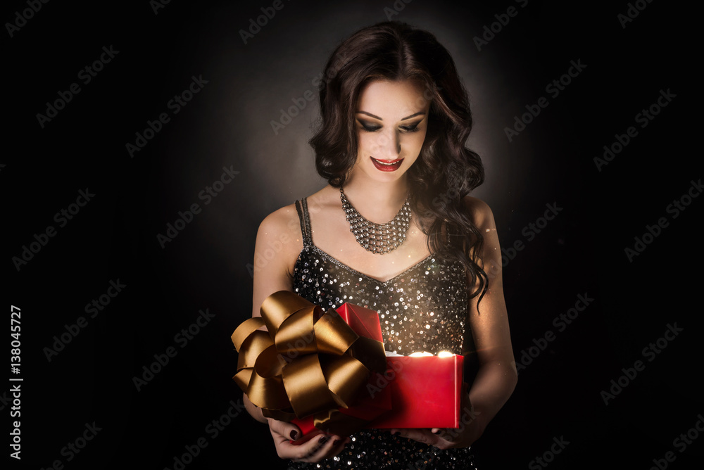 Surprised woman is opening red gift box dark background Surprised woman is opening red gift box dark background