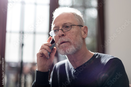 Senior man talking on phone, hard light and flare effect