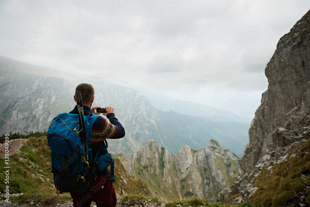 Man hiking in the mountains photographing nature