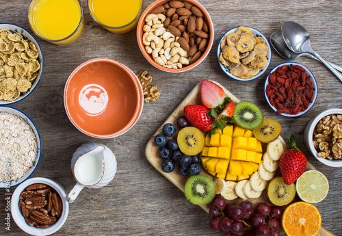 Healthy and various morning breakfast selection:  cereals, nuts, fruits, juice, berries, selective focus. Top view