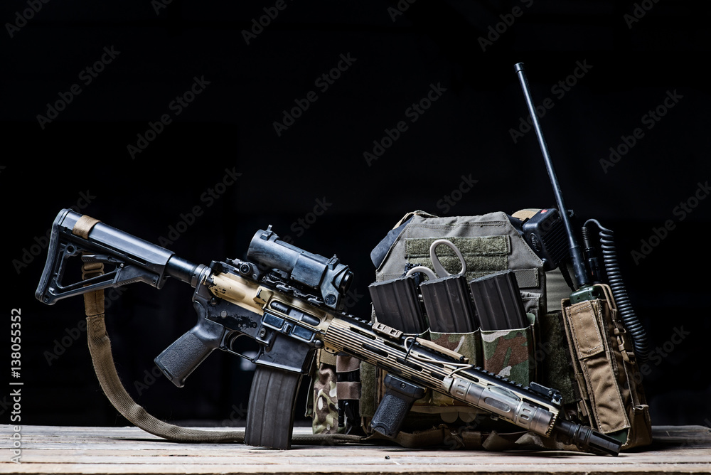 Helmet,rifle and military flak jacket/Assault rifle with sight,bulletproof vest,ammo and radio on dark background Helmet,rifle and military flak jacket/Assault rifle with sight,bulletproof vest,ammo and radio on dark background