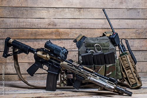 Rifle with telescopic sight and bulletproof vest with radio/Assault rifle with telescopic sight,bulletproof vest,ammo and radio on wooden background