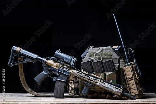 Helmet,rifle and military flak jacket/Assault rifle with sight,bulletproof vest,ammo and radio on dark background