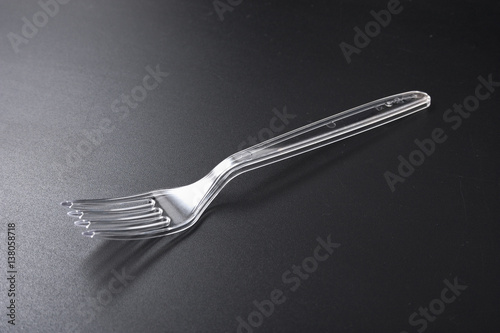 disposable plastic tableware. fork and knife on black background.