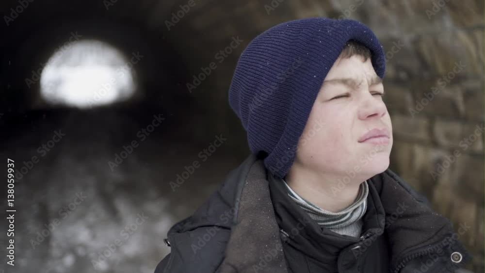 Hopeless poor boy looking out at the long tunnel.