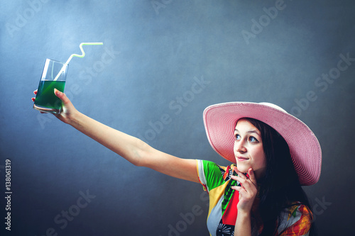 Stylish senior woman drinking cocktail in studio