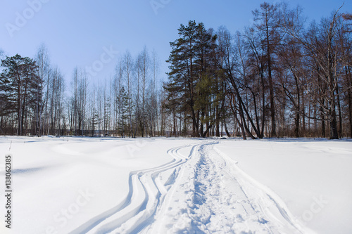 Footprints in the snow  Snow background  Winter background  Winter snow or Winter field. Russia. Early spring.