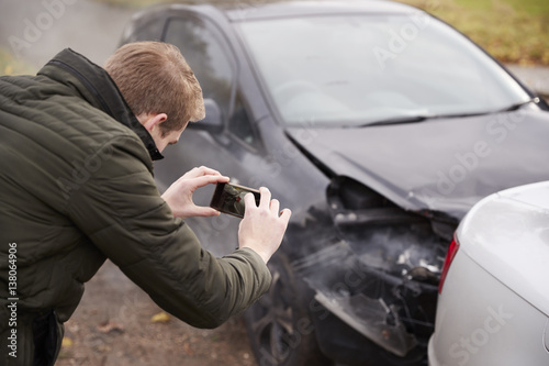 Man Taking Photo Of Car Accident On Mobile Phone