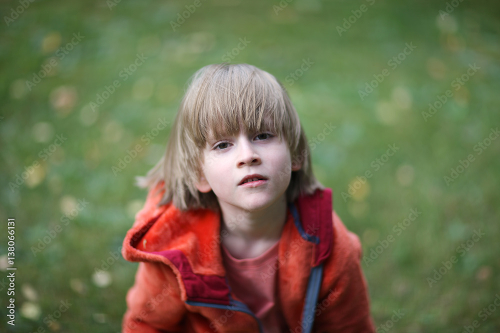 Portrait of a boy in a stylish dress on a lawn in a park Portrait of a boy in a stylish dress on a lawn in a park