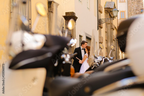 Groom and bride in the city near mopeds, selective focus