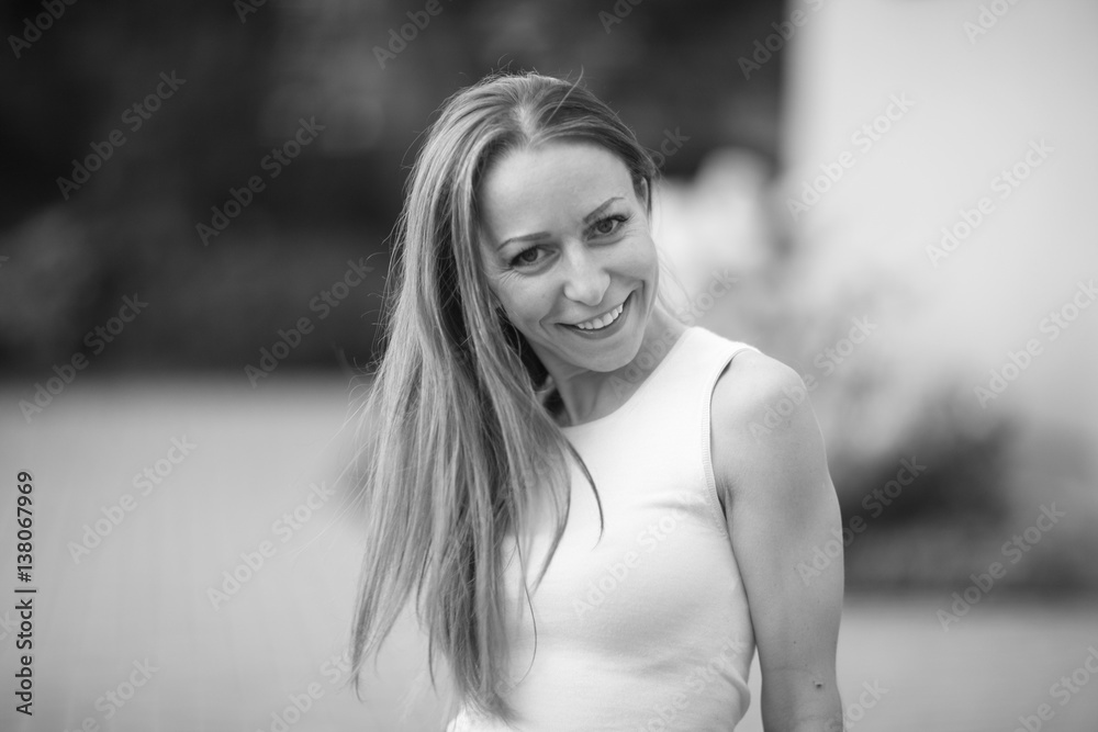 Monochrome portrait of a young woman with long hair outdoors