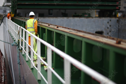 Port workers dragged slings for loading on board ship cargo ship photo