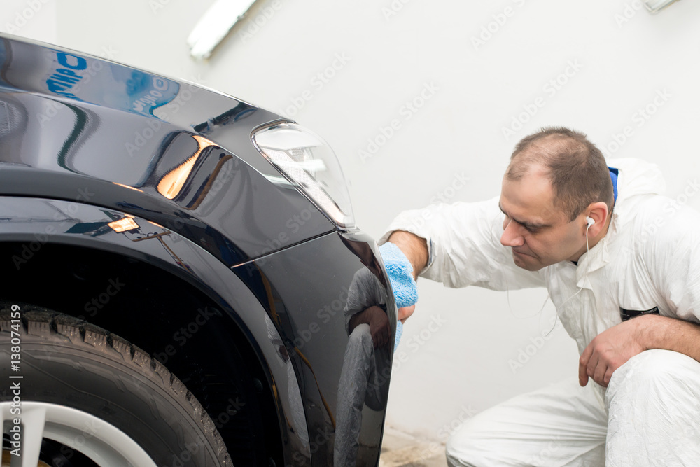 Man on a car wash polishing car with a polish machine Man on a car wash polishing car with a polish machine