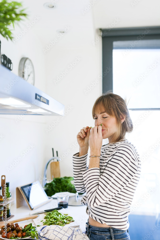 Young woman cooking vegan pasta in her kitchen