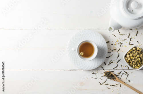 Hot tea with tea pot on white wood background