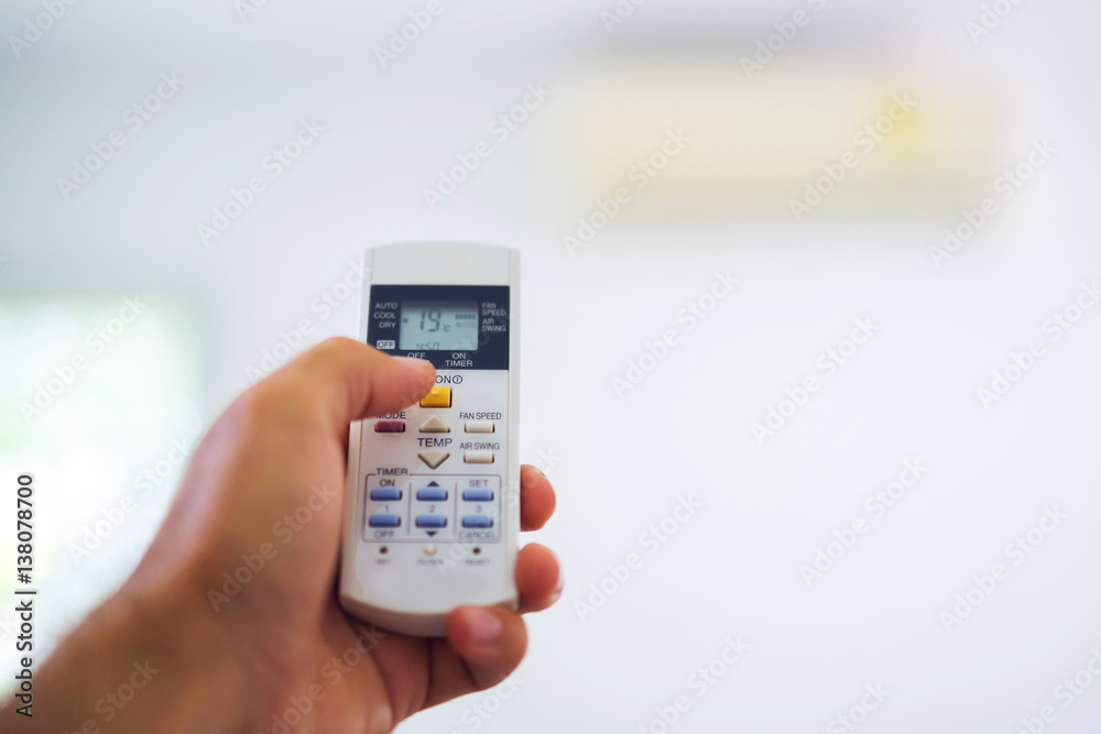Remote control from the air conditioner in the hands of the men of remote control. The temperature and the climate in the building. Remote control from the air conditioner in the hands of the men of remote control. The temperature and the climate in the building.