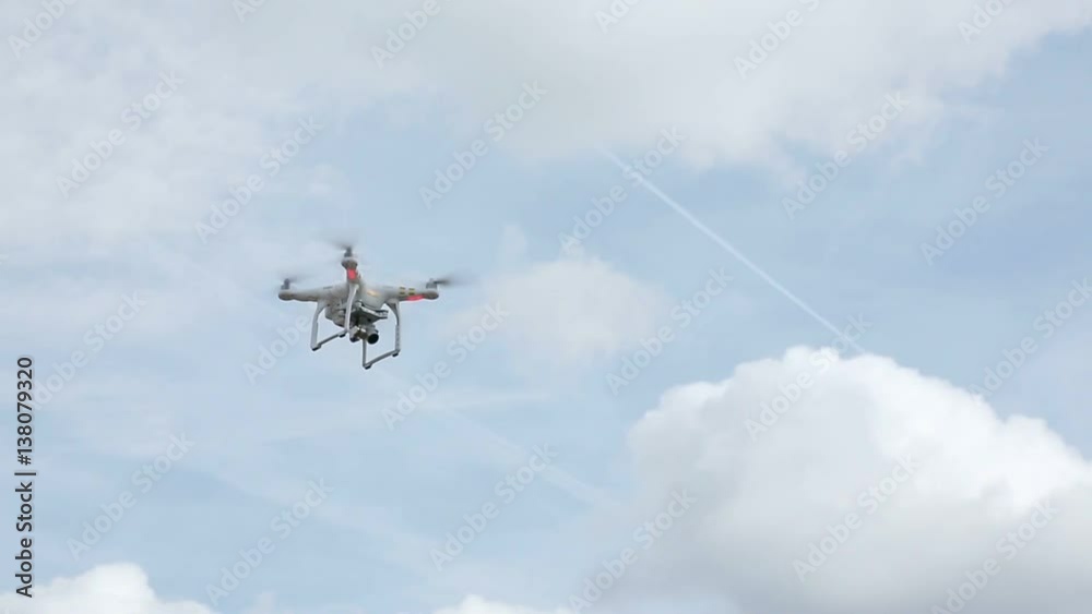 Quadcopter flying in the sky at sunny day Quadcopter flying in the sky at sunny day