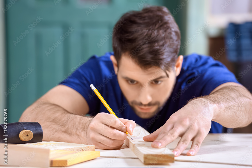 portrait of concentrated carpenter working taking measures of wooden plank portrait of concentrated carpenter working taking measures of wooden plank