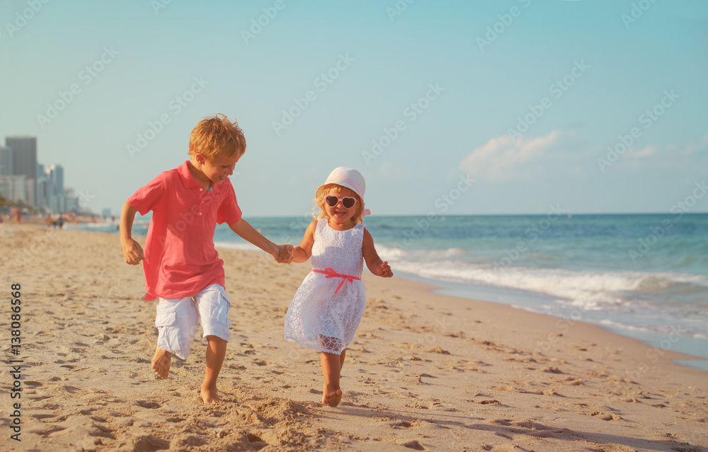 little boy and girl running at beach