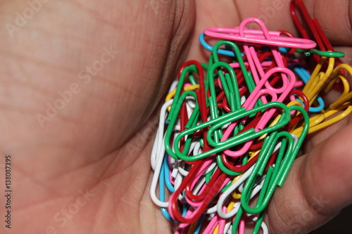 Colorful paperclips in hand