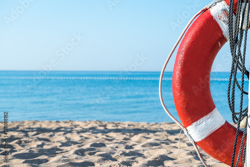 фотографія life preserver on a background of the sandy beach and the sea